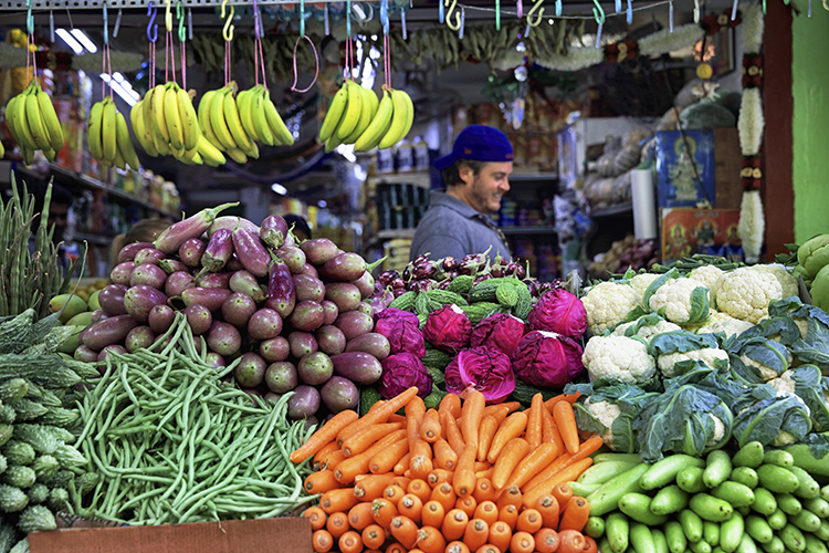 a vegetable and fruit seller in the local market makes for an authentic experience